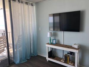 een woonkamer met een flatscreen-tv aan de muur bij Gorgeous 2 BR/2 BR Newly Renovated BeachFront Condo in Myrtle Beach