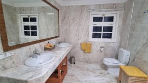 a bathroom with two sinks and a toilet and a mirror at Casa Natalie La Marina in Puerto Calero +23 photos