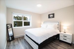 een slaapkamer met een wit bed en een raam bij NN - The Falls B - Downtown 2-bed 1-bath in Whitehorse