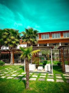 a resort with palm trees and chairs in the yard at Aromë natyre by AlaraFarm in Durrës