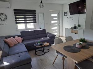 a living room with a blue couch and a table at Villa Ana in Posedarje