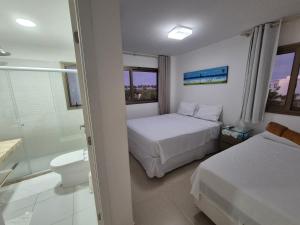 a hotel room with two beds and a bathroom at Condominio Mediterraneo - Iberostate in Praia do Forte