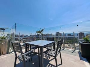 una mesa y sillas en un balcón con vistas en Your stay steps away from takeoff!, en Guatemala