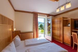 una camera d'albergo con un letto e una grande finestra di Hotel Garni Thermenglück a Unterlamm