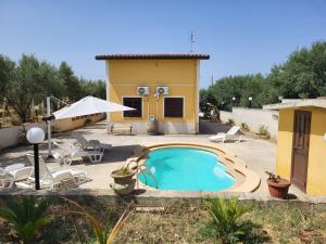 a small pool in a yard with a house at Villa Rosa in Balestrate