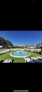 una grande piscina con sedie in cortile di Mobilhome comfort à la montagne a Saint-Auban