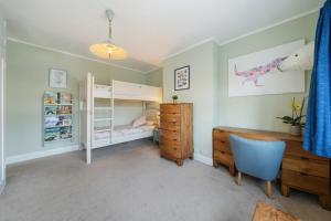 a bedroom with a bunk bed and a desk at A delightful 4-bedroom home with a private garden in London