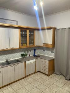 una cocina con armarios de madera y una luz azul en Central Village House, en Lépoura