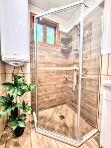 a shower with a glass door in a bathroom at Къмпинг и Бунгала Брусен Хил - Camping and Bungalows Brusen Hill 