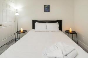 a bedroom with a large white bed with two tables at NN - The Evelyn - Whistlebend 1-bed 1-bath in Whitehorse