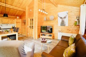 ein Wohnzimmer mit einem Sofa und einem TV in einer Hütte in der Unterkunft Ferienpark Harmsen in Cuxhaven