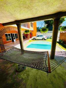 eine Hängematte vor einem Haus mit einem Pool in der Unterkunft La casa de doña Juanita 