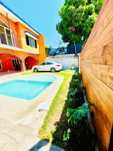 ein Auto, das vor einem Haus mit Pool parkt in der Unterkunft La casa de doña Juanita 