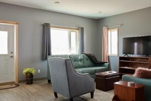 a living room with a green couch and a tv at NN - The Kluane - Whistlebend 3-bed 2-bath in Whitehorse