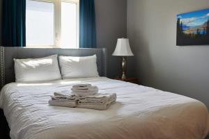 een slaapkamer met een bed met handdoeken erop bij NN - The Kluane - Whistlebend 3-bed 2-bath in Whitehorse