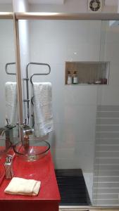un bancone rosso in un bagno con doccia di Experimenta la automatizacion: Departamento inteligente a Santiago del Estero Altre 31 foto