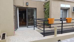 un balcone di una casa con due vasi arancioni di Experimenta la automatizacion: Departamento inteligente a Santiago del Estero