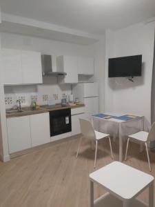 Una cocina con gabinetes blancos y una mesa y sillas. en Casa Sauli, en Génova