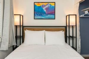 ein Schlafzimmer mit einem Bett mit weißen Kissen und zwei Lampen in der Unterkunft NN - The Summit - Copper Ridge 1-bed 1-bath in Whitehorse