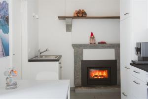 ein Wohnzimmer mit einem Kamin und einem Waschbecken in der Unterkunft Rustico in pietra in Brissago