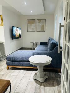 a living room with a blue couch and a table at Village at 17 in Gaborone