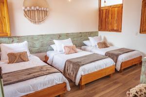 2 camas en una habitación con suelo de madera en Raizes AXM I Casa Campestre I Armenia, Quindío, Colombia, en Armenia