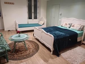 ein Schlafzimmer mit einem Bett, einem Tisch und einem Sofa in der Unterkunft un petit studio moderne et conviviale 