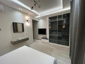 a white room with a bed and a television at Luxurious Villa at North Coast in El Dab‘a