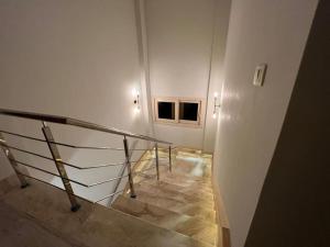 a staircase with a metal railing in a building at Luxurious Villa at North Coast in El Dab‘a