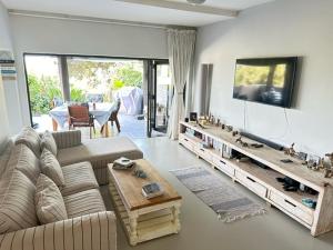 a living room with a couch and a flat screen tv at Modern Beachfront Home in Westbrook