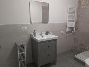 Un baño blanco con lavabo y espejo. en Casa Sauli, en Génova