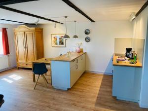 a kitchen with a blue island in a room at Pension Hessbögel in Grünendeich