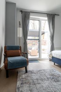 1 dormitorio con silla, 1 cama y puerta corredera de cristal en Tölgyes Villa, en Kőszeg