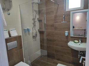 een badkamer met een douche en een wastafel bij Apartmani Happy House in Surčin
