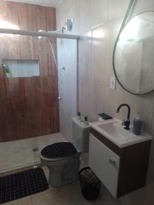 a bathroom with a shower and a toilet and a sink at Kit Apto Aconchegante na praia do forte in Cabo Frio