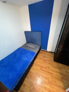 un piccolo letto in una camera con parete blu di Hostel Bogotá Niza Tu sitio a Bogotá