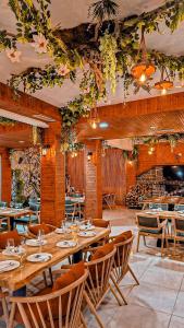 a restaurant with wooden tables and chairs and flowers at Aromë natyre by AlaraFarm in Durrës