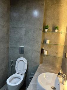 a bathroom with a white toilet and a sink at Your homely studios in Ghaziabad