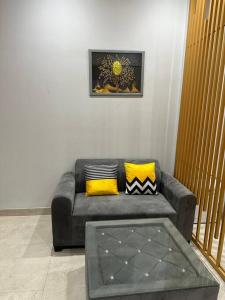 a living room with a couch with yellow pillows at Your homely studios in Ghaziabad