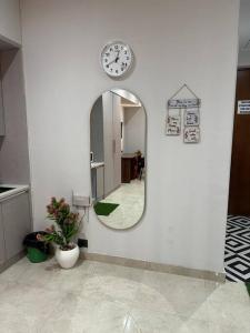 a mirror and a clock on a white wall at Your homely studios in Ghaziabad