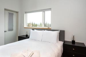 een slaapkamer met een groot wit bed en een raam bij NN - The Flame - Downtown 1-bed 2-bath in Whitehorse