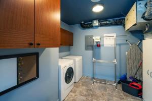 NN - The Flame - Downtown 1-bed 2-bath في وايتهورس: غرفة صغيرة لغسيل الملابس مع غسالة ومجفف