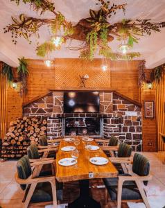 a dining room with a table and a fireplace at Aromë natyre by AlaraFarm in Durrës