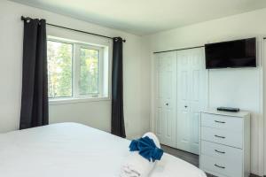 een slaapkamer met een bed en een flatscreen-tv bij NN The Homestay Crestview 2bed 1 5bath in Whitehorse