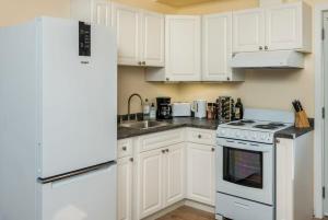 a kitchen with white cabinets and a white refrigerator at NN The Lavendar B Whistlebend 1bed 1bath in Whitehorse