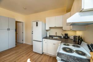 a kitchen with white cabinets and a white refrigerator at NN The Lavendar B Whistlebend 1bed 1bath in Whitehorse