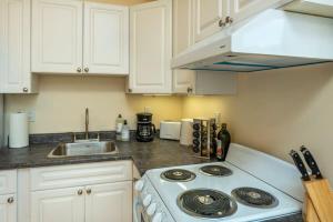 a kitchen with a white stove and a sink at NN The Lavendar B Whistlebend 1bed 1bath in Whitehorse
