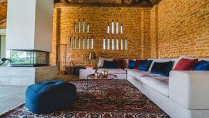 a living room with a couch and a brick wall at Gardenguesthouse Mlinar in Fokovci