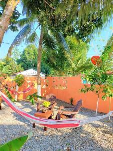 a hammock and chairs on a beach with palm trees at Villa Familiar en Río San Juan con Wifi BBQ Piscina @drvacationsrental in Río San Juan