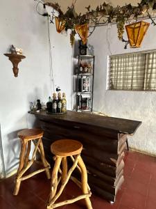 bar z 2 drewnianymi stołkami w pokoju w obiekcie Casaca w mieście Concepción de Ataco